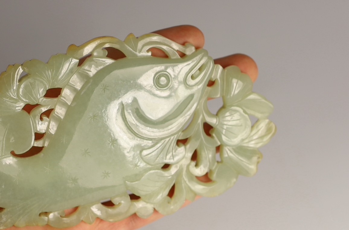 A Chinese pale celadon jade 'fish' plaque, 18th/19th century, 16.7cm long, 8.5cm high, later wood stand for use as a table screen